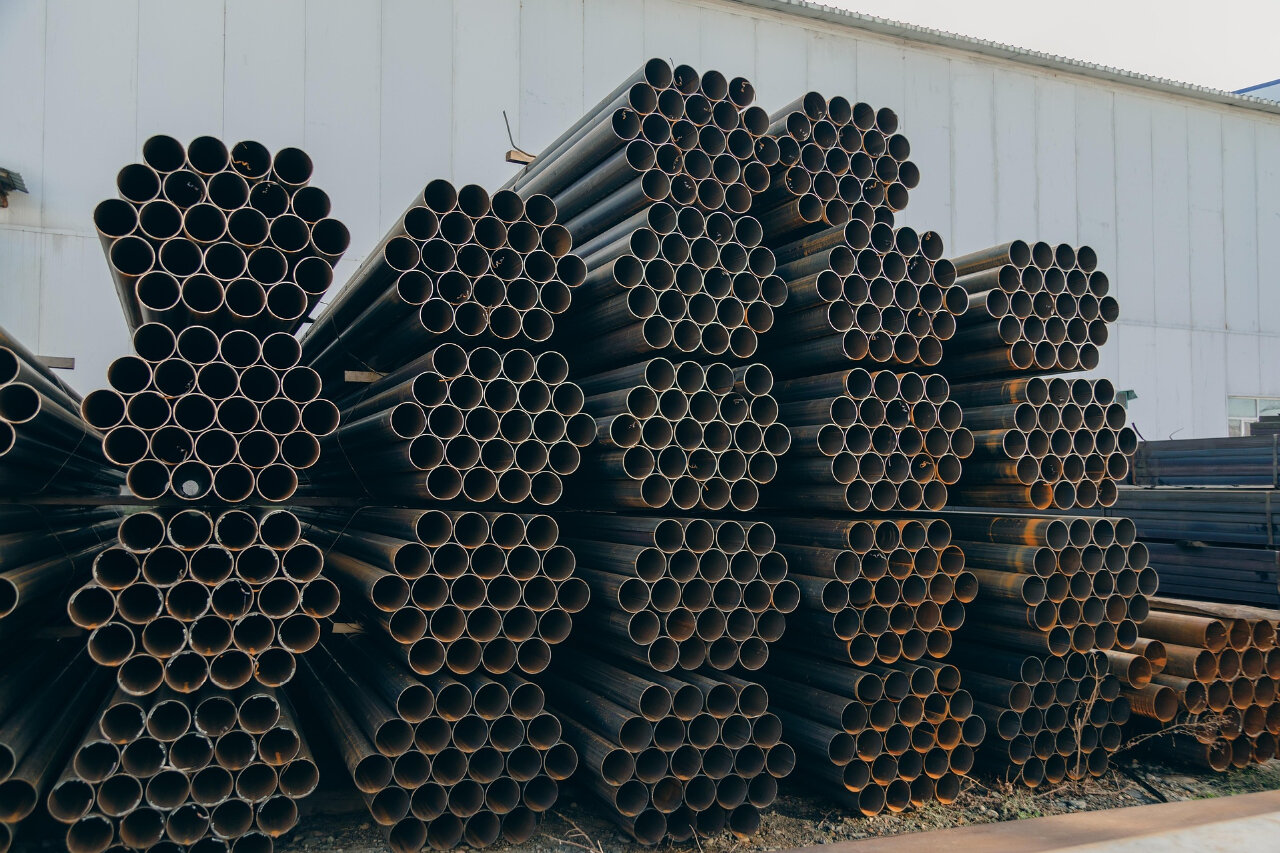 Steel metal pipes sitting piled on top of eachother ready to be laser cut with a laser cutting machine